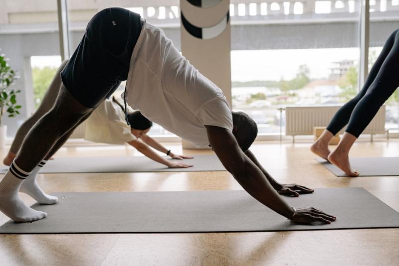 Grupo practicando yoga, postura del perro boca abajo, sobre esterillas