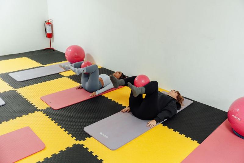 Clase grupal de pilates con pelotas en un gimnasio sencillo