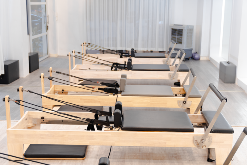 Fila de máquinas reformer de madera en un estudio de pilates