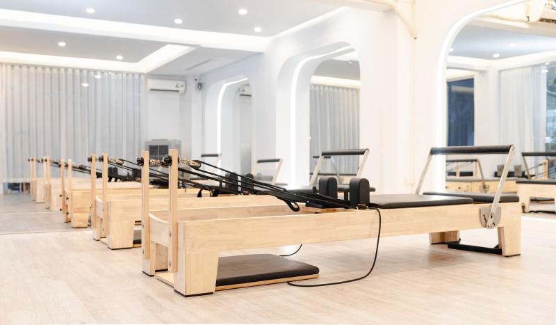 Estudio de pilates con varias máquinas reformer de madera